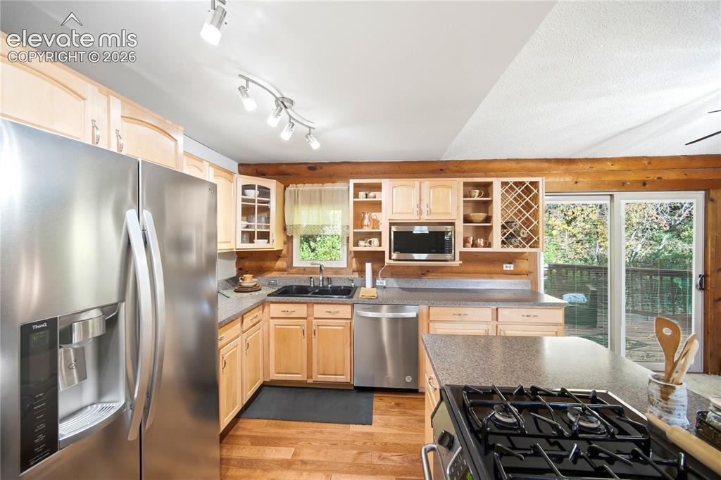 Image 10 of 34: Kitchen featuring wood-finish flooring, light wood cabinetry, stainless ste