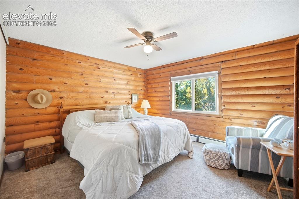 Image 14 of 34: Wood-paneled walls, ceiling fan with integrated lighting, window with exter