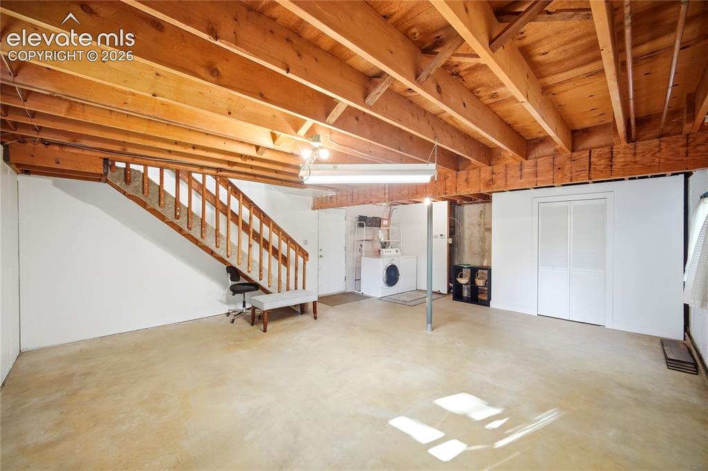 Image 19 of 34: Open unfinished basement with exposed wood joists and concrete flooring