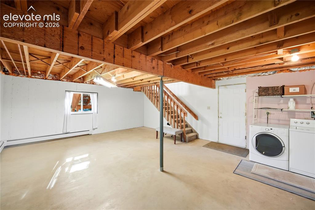 Image 20 of 34: Exposed ceiling joists with unfinished subfloor above, concrete flooring, w