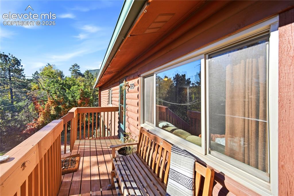 Image 23 of 34: Wood-sided exterior featuring a full-width deck with wood railings