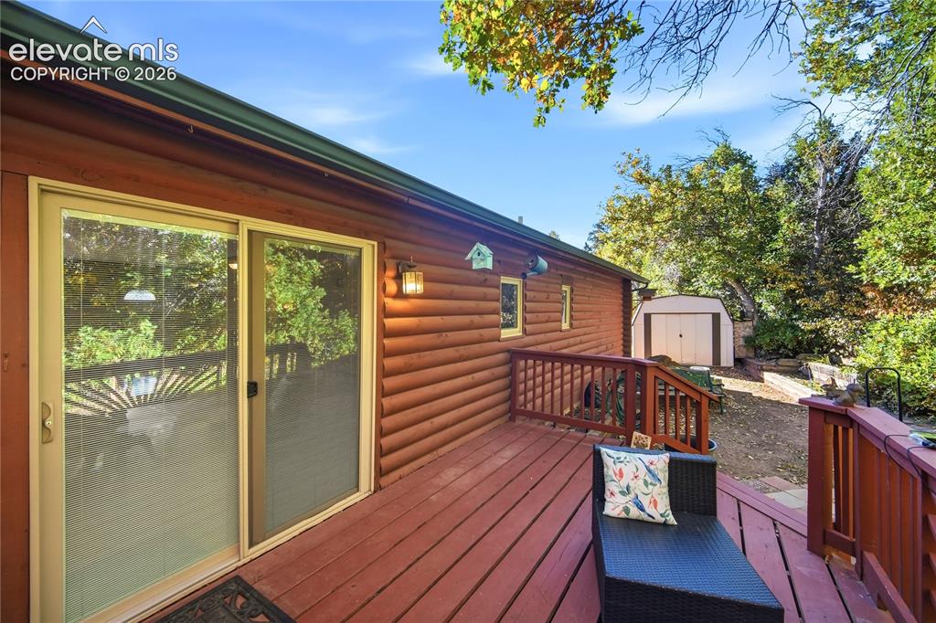 Image 24 of 34: Wood-clad exterior, sliding glass door, and a spacious wood deck