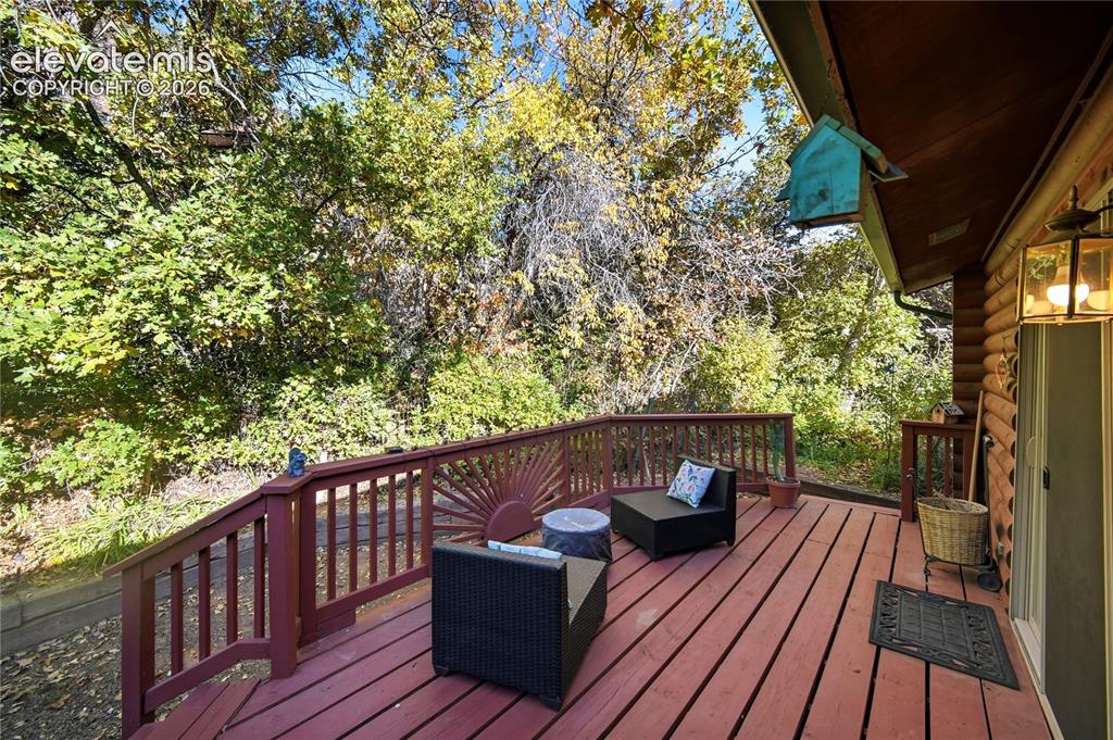 Image 25 of 34: Expansive exterior deck with wood-finish flooring, a coordinating wood rail