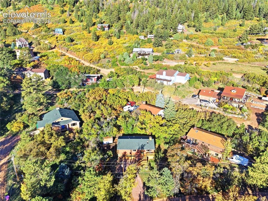 Image 28 of 34: Multiple residences set within a hillside landscape featuring extensive tre