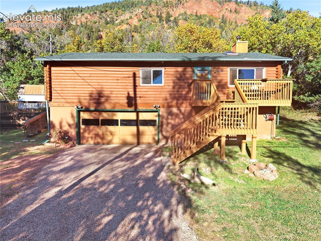 Image 30 of 34: Wood-clad exterior with a green roof, attached garage, and a multi-level wo
