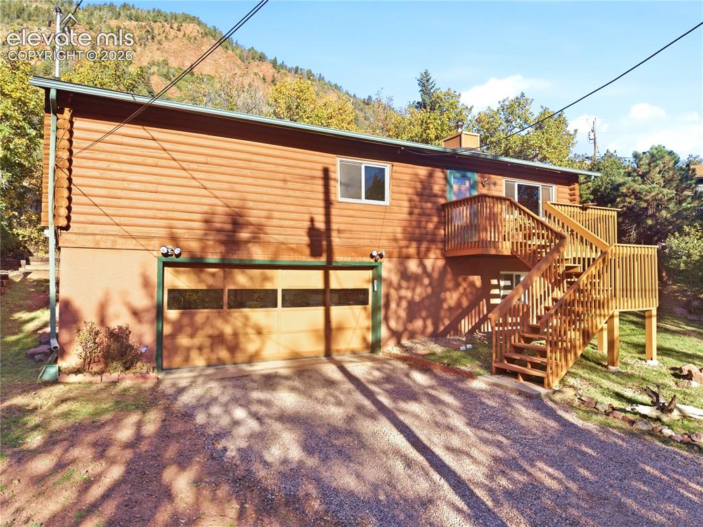 Image 31 of 34: Wood-finish siding exterior featuring a multi-level deck, exterior staircas