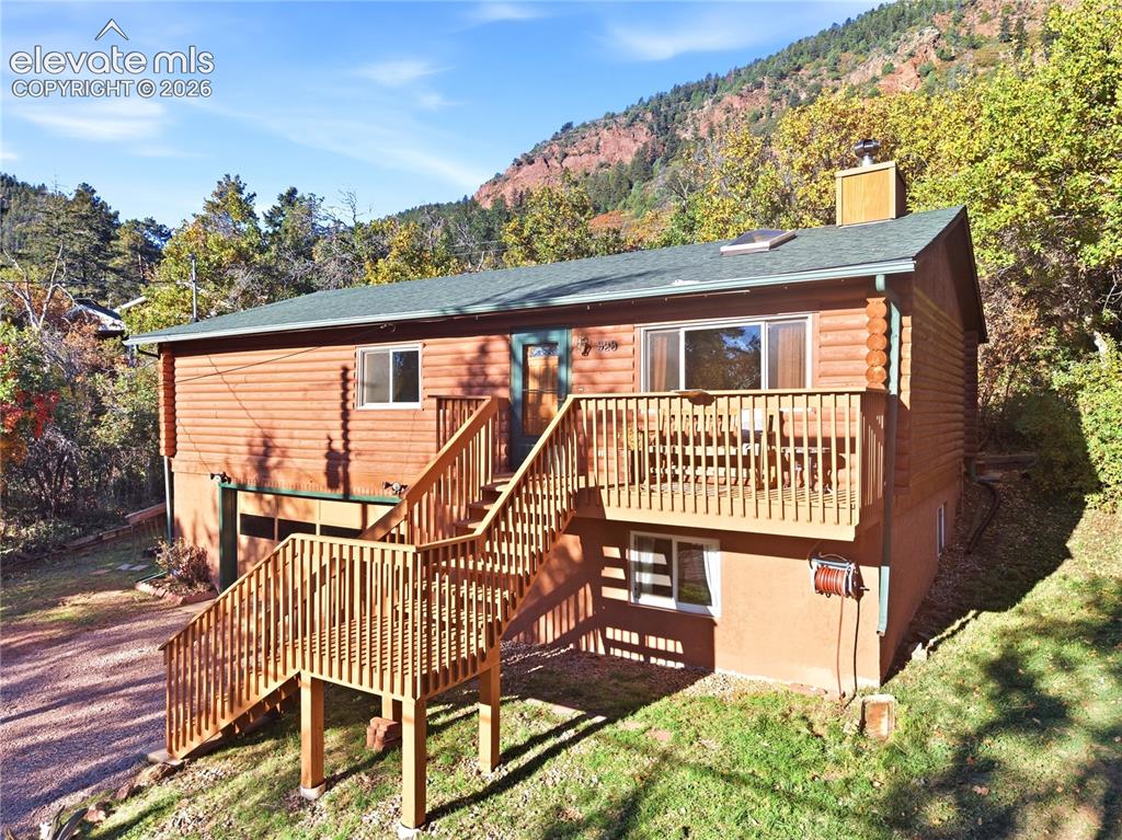 Image 32 of 34: Log-style siding exterior with a dark-pitched roof and a prominent chimney
