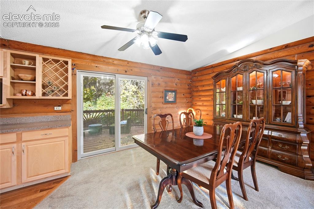 Image 6 of 34: Log wall construction, built-in cabinetry with wine storage, sliding glass 