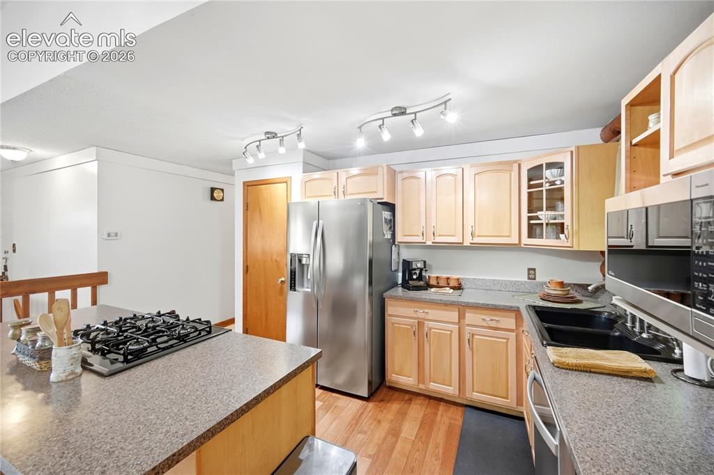 Image 7 of 34: Kitchen featuring wood-finish flooring, light wood cabinetry, stainless ste