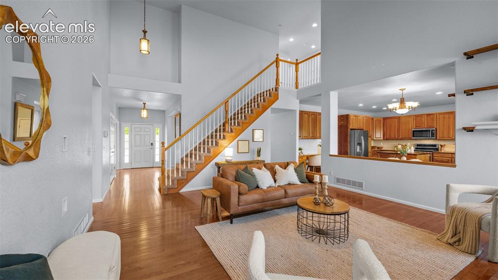 Image 11 of 43: Vaulted ceilings in a spacious living area featuring wood-finish flooring, 