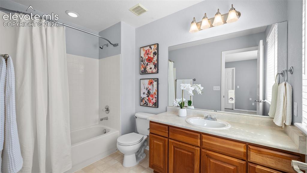 Image 23 of 43: Bathroom featuring a full vanity with wood cabinetry, a large wall-mounted 