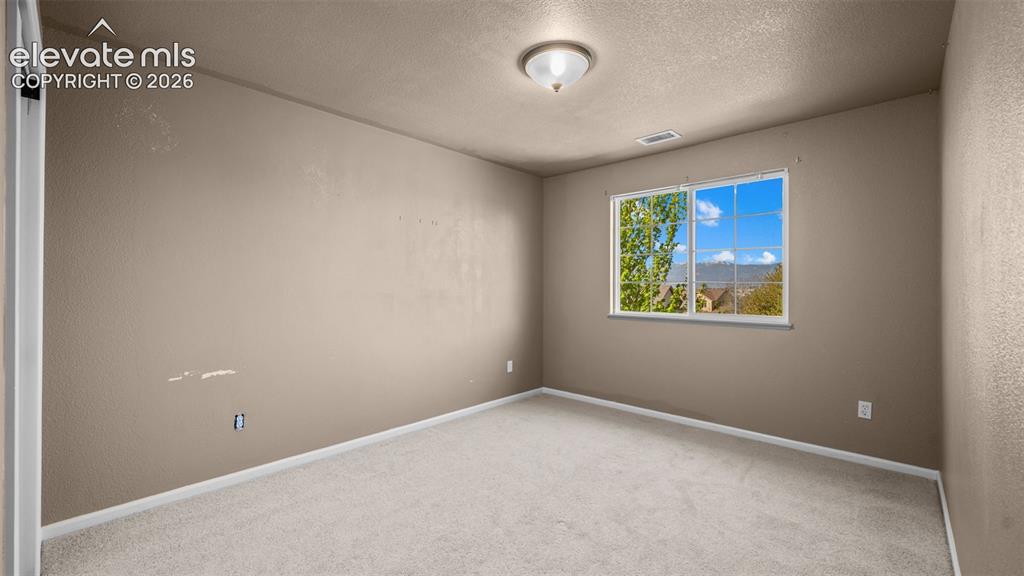 Image 26 of 43: Room featuring neutral-toned walls, white baseboards, and light-colored car