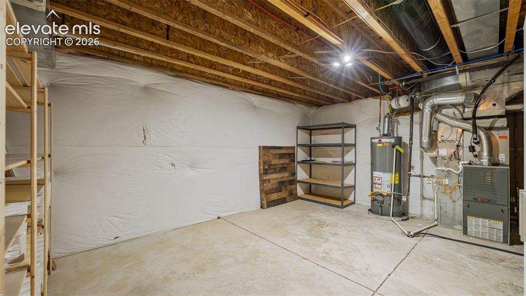 Image 34 of 43: Unfinished basement featuring exposed wood joists, concrete flooring, and u