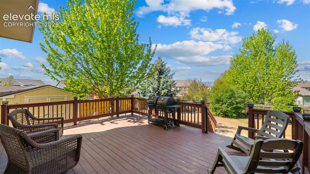 Image 39 of 43: Spacious outdoor deck with rich wood-finish flooring, sturdy railings with 