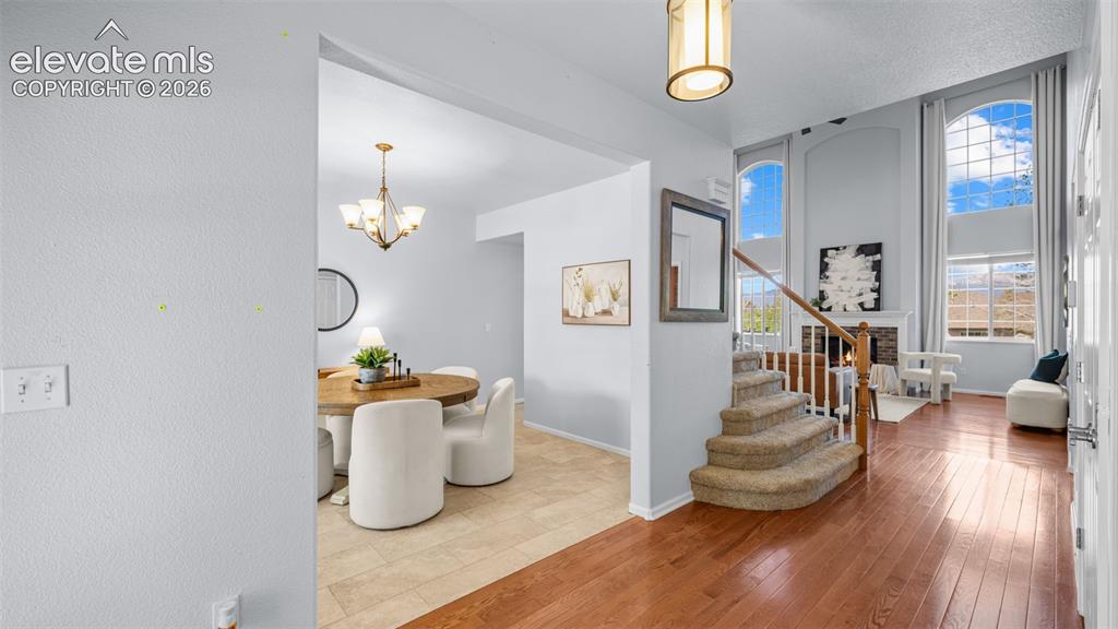 Image 5 of 43: Two-story entry foyer with hardwood flooring and a carpeted staircase with 