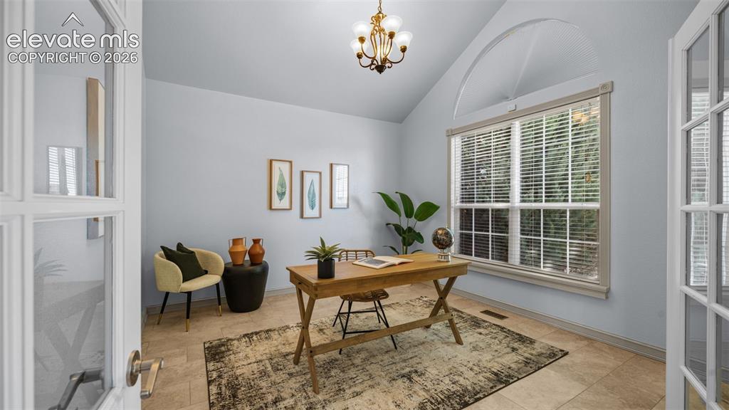 Image 8 of 43: Vaulted ceiling room featuring French doors, a large window with an arched 