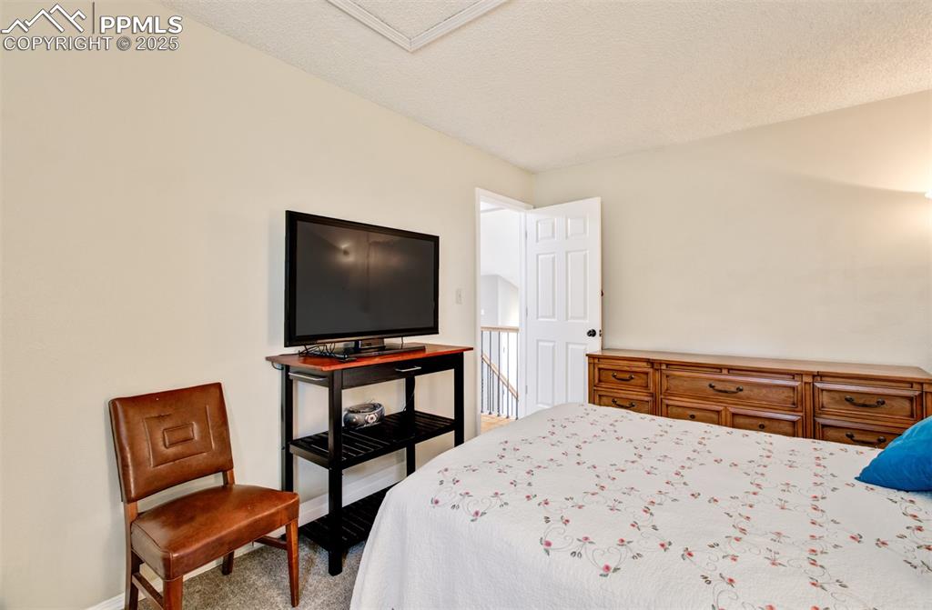 Image 13 of 25: Bedroom with carpet floors and a textured ceiling