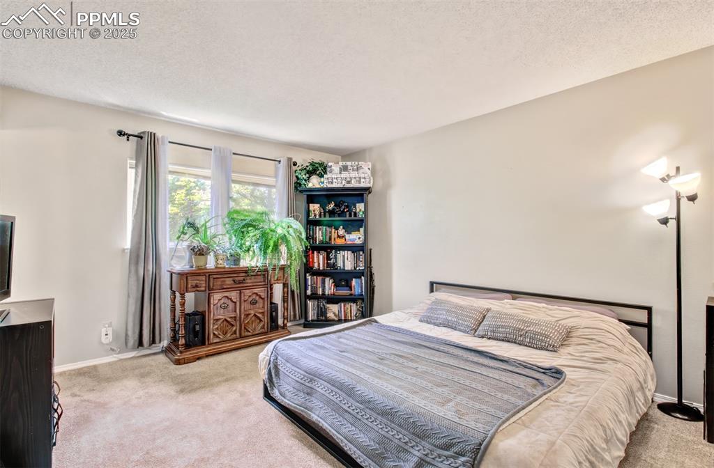 Image 15 of 25: Bedroom featuring carpet and a textured ceiling