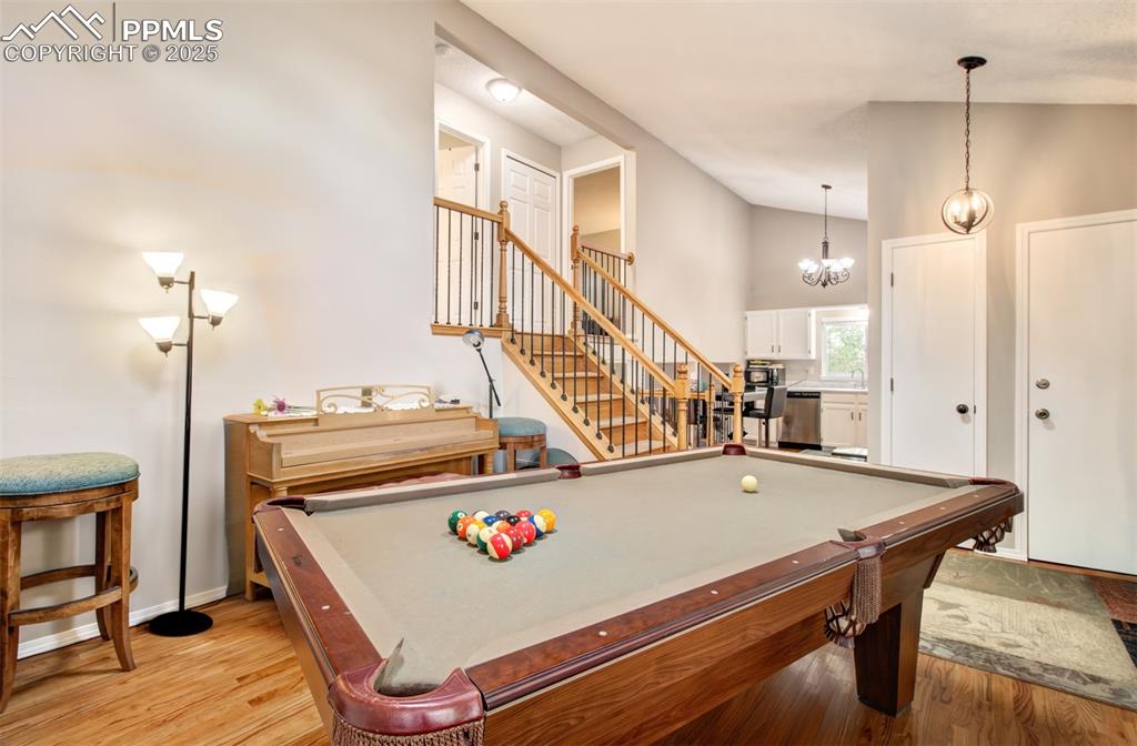 Image 4 of 25: Rec room featuring light wood-type flooring, billiards, high vaulted ceilin