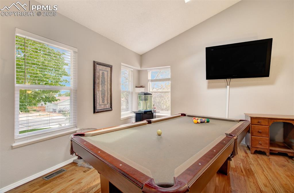 Image 7 of 25: Playroom with pool table, vaulted ceiling, and light wood finished floors