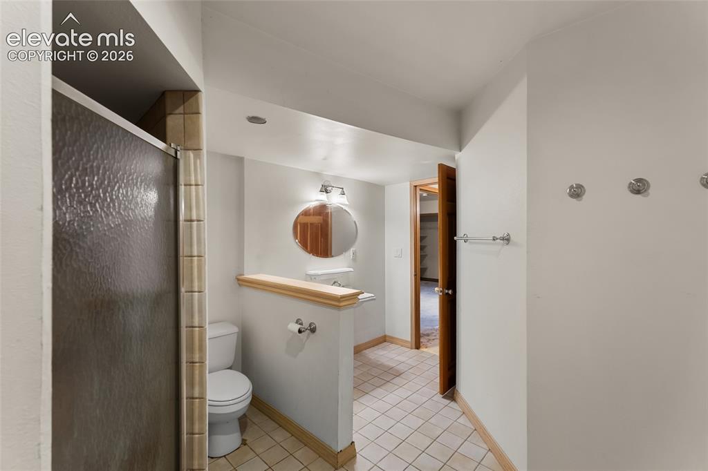 Image 24 of 49: Tiled flooring with a partial wall separation