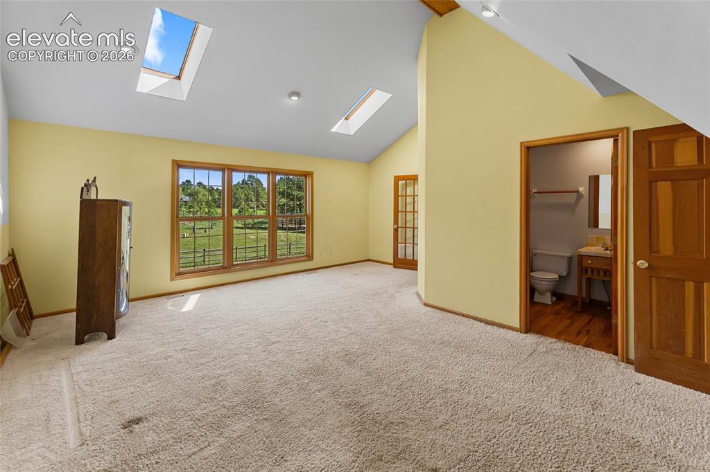 Image 29 of 49: Vaulted ceilings with recessed lighting and skylights, a three-panel window