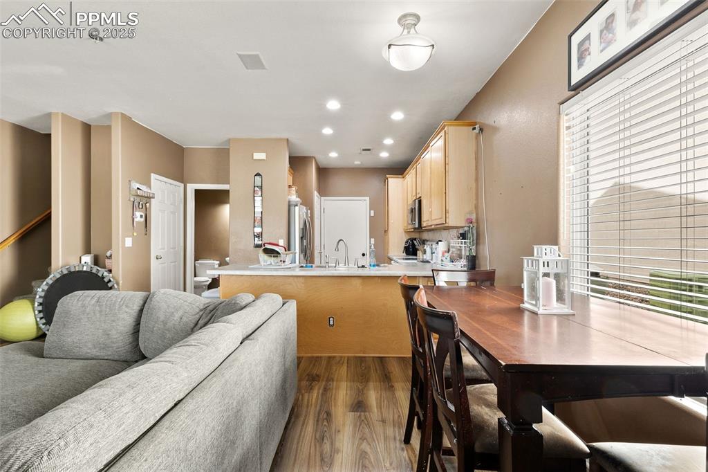Image 10 of 29: Kitchen featuring light brown cabinets, light countertops, a peninsula, woo