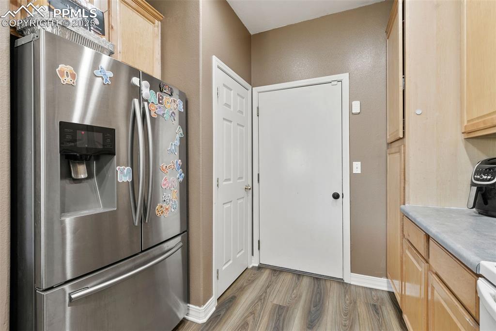 Image 15 of 29: Kitchen with stainless steel fridge, light brown cabinets, light wood-type 