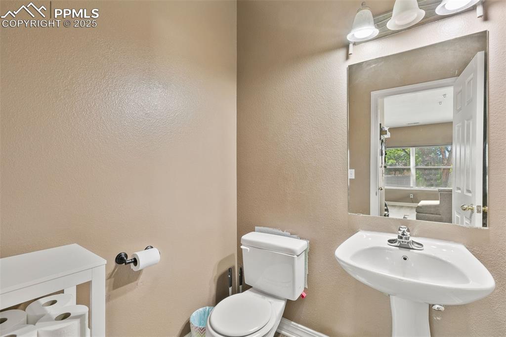 Image 16 of 29: Half bath with a textured wall and toilet