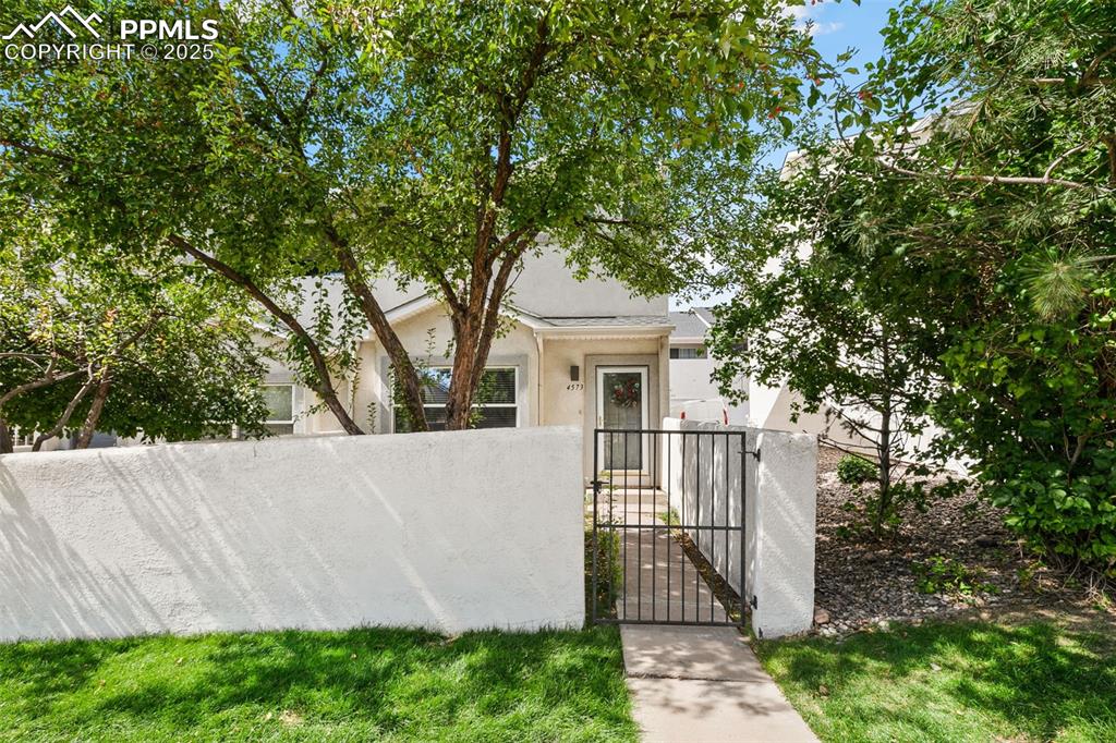 Image 2 of 29: View of front of home featuring stucco siding, a gate, and a fenced front y