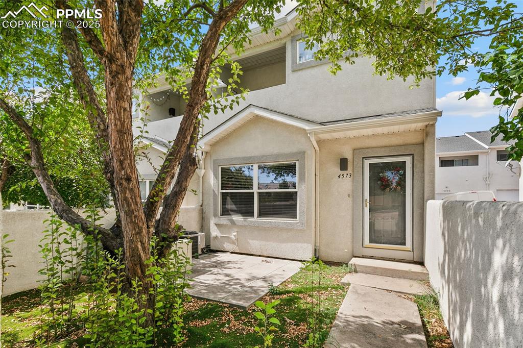 Image 3 of 29: View of front of home featuring stucco siding and a patio