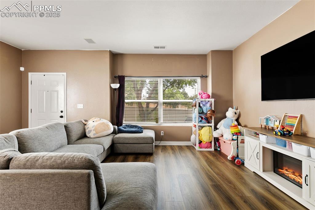 Image 5 of 29: Living area featuring dark wood-style floors and baseboards