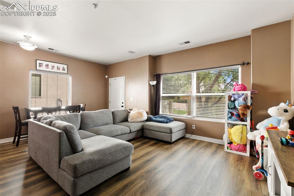 Image 6 of 29: Living area featuring baseboards and wood finished floors