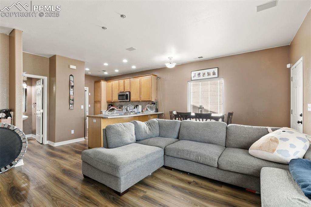 Image 8 of 29: Living room featuring dark wood-style flooring and recessed lighting