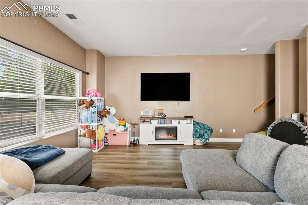 Image 9 of 29: Living room featuring wood finished floors and baseboards