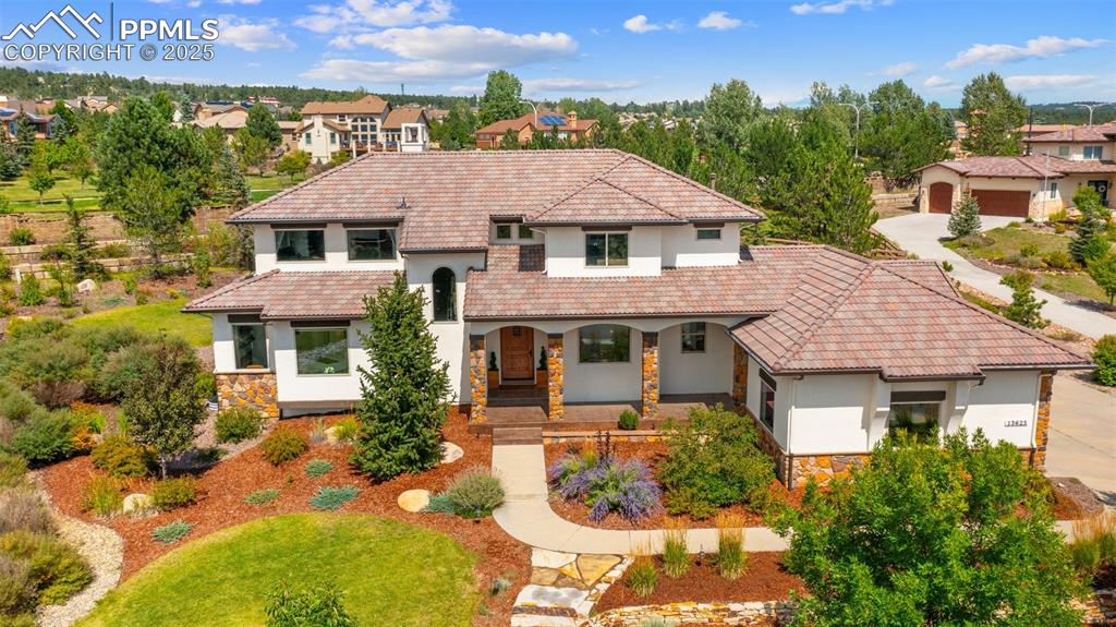Caption: Mediterranean / spanish home with stone siding, a porch, stucco siding, and a tiled roof