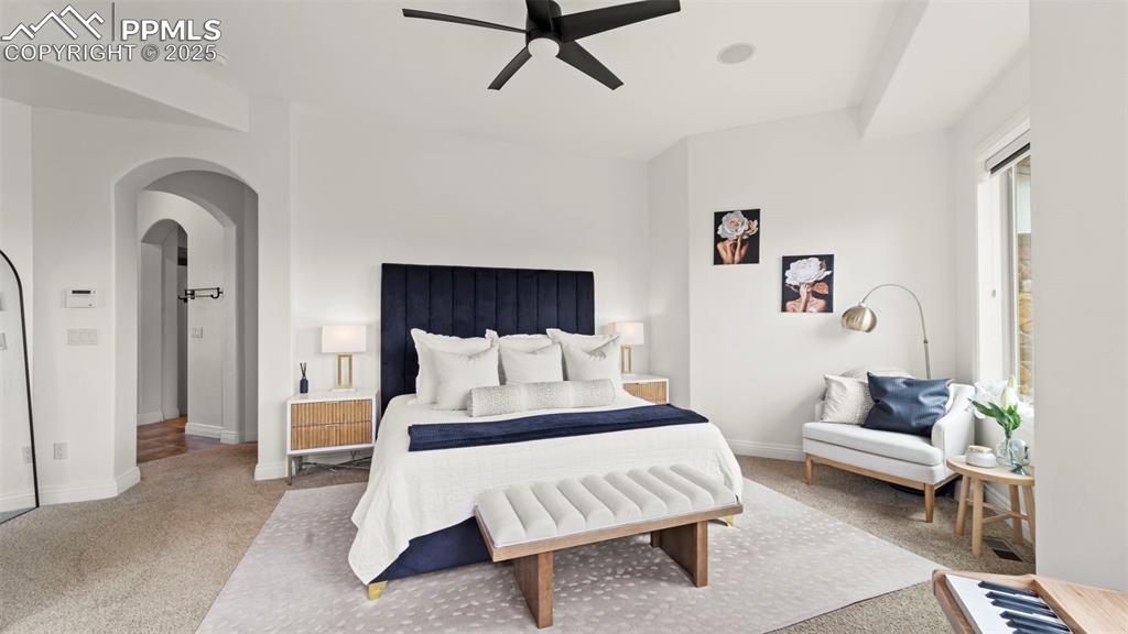 Image 19 of 50: Bedroom with carpet, arched walkways, and a ceiling fan