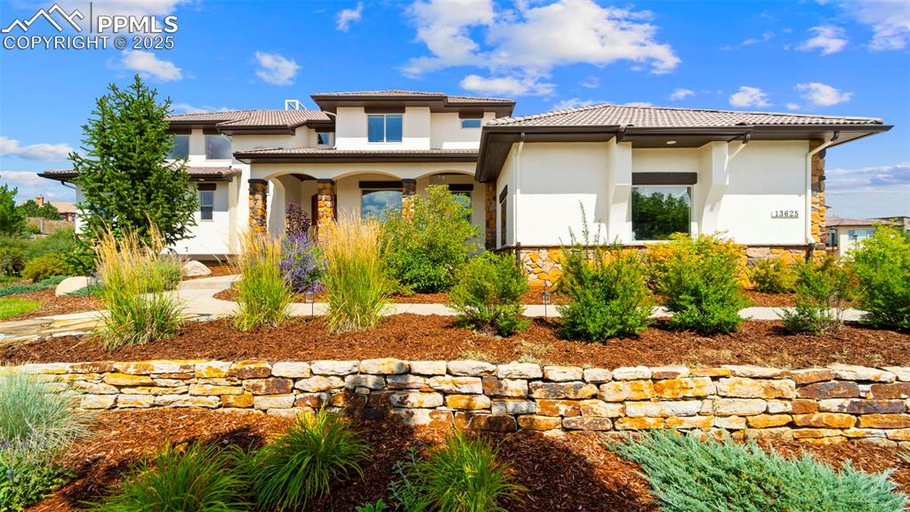 Image 2 of 50: View of front of property featuring stucco siding, a porch, and a tiled roo