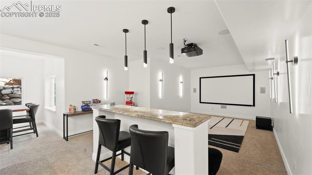 Image 29 of 50: Home theater room featuring light carpet and healthy amount of natural ligh