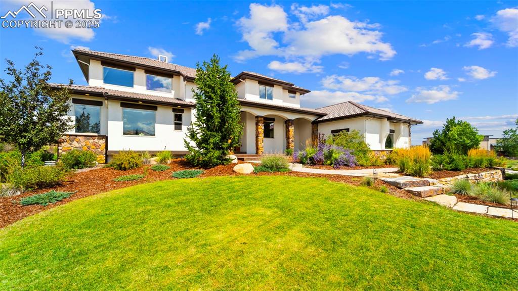 Image 3 of 50: Mediterranean / spanish-style home with stucco siding, stone siding, a fron