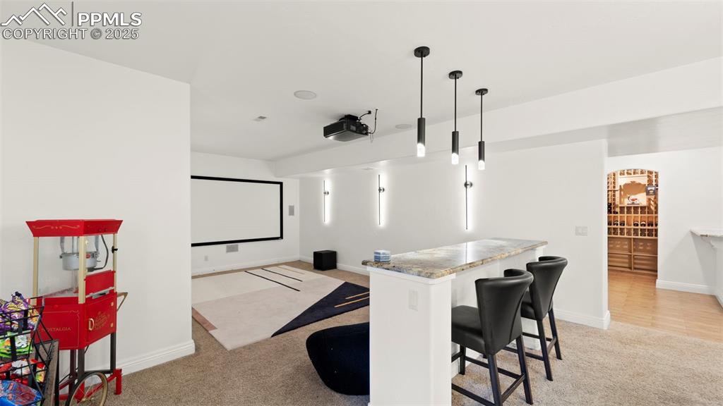 Image 30 of 50: Home theater featuring light colored carpet and baseboards