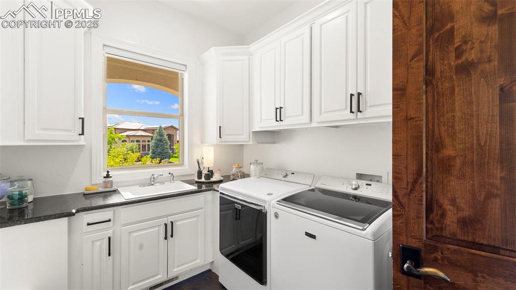 Image 7 of 50: Laundry area with independent washer and dryer and cabinet space