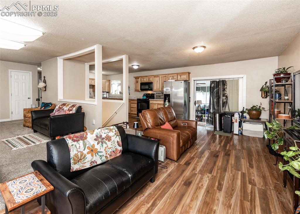 Image 14 of 42: Living room with wood finished floors and a textured ceiling