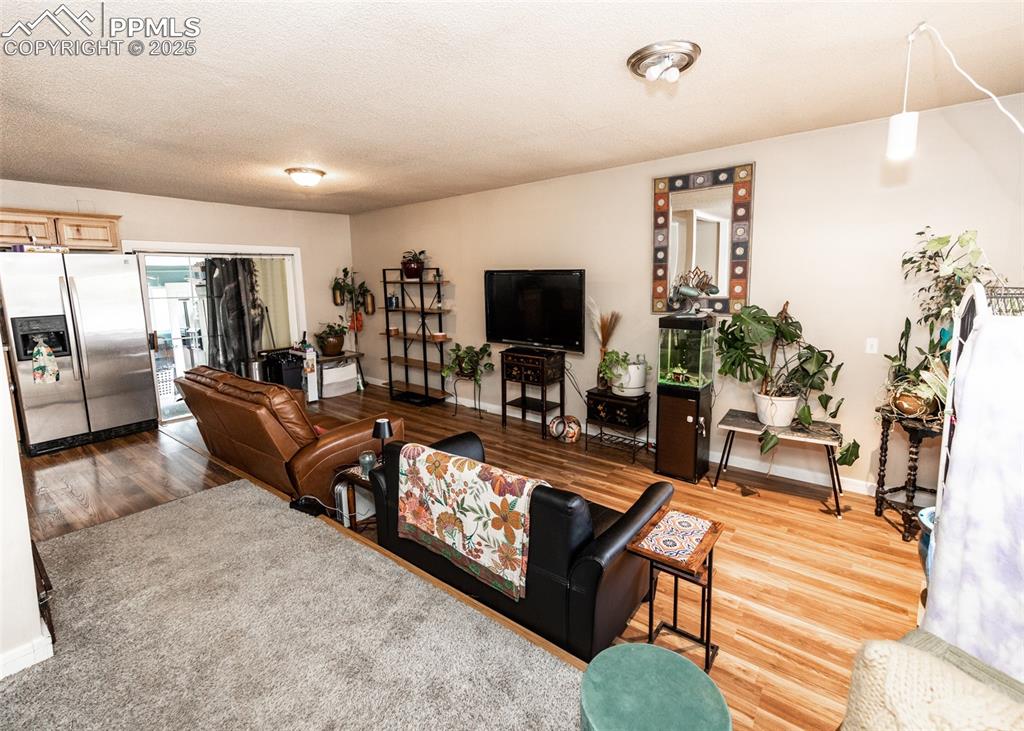 Image 19 of 42: Living area with baseboards and wood finished floors