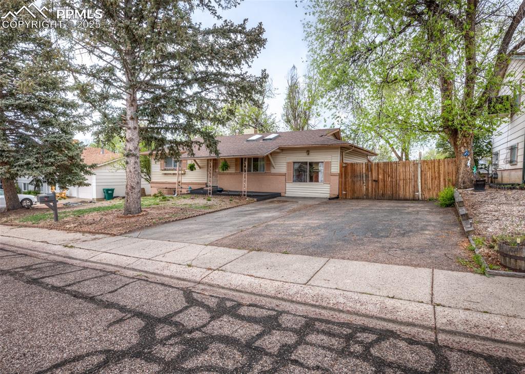 Image 2 of 42: Single story home featuring asphalt driveway, fence, and a shingled roof
