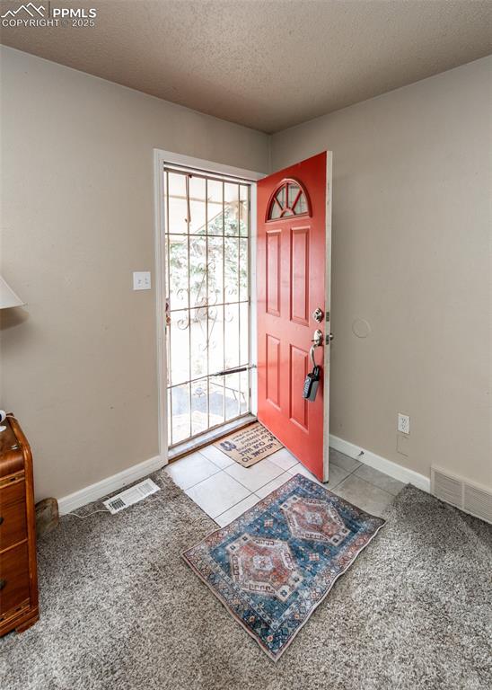 Image 3 of 42: Foyer entrance featuring baseboards, carpet, and a textured ceiling