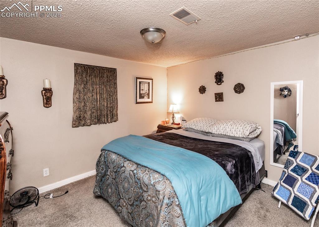 Image 36 of 42: Carpeted bedroom with baseboards and a textured ceiling