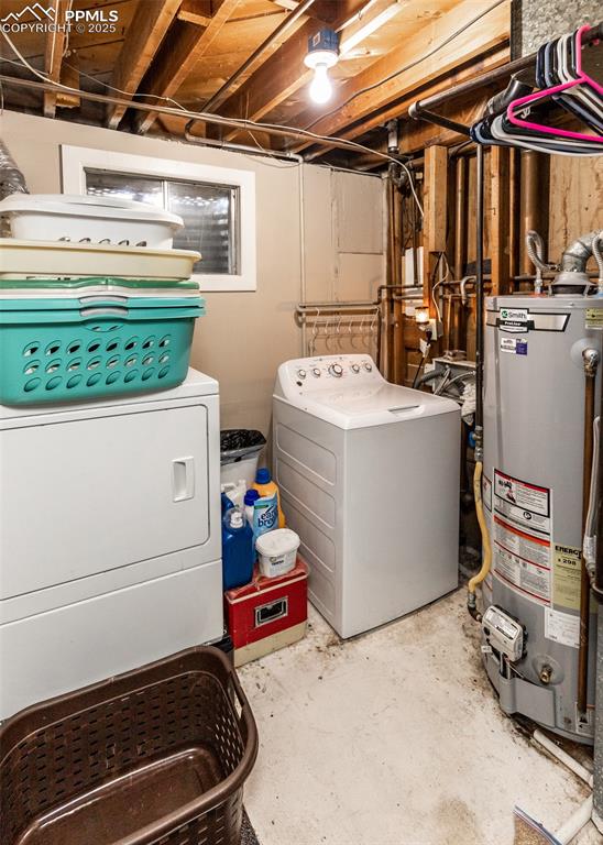 Image 38 of 42: Washroom with water heater and washer and clothes dryer