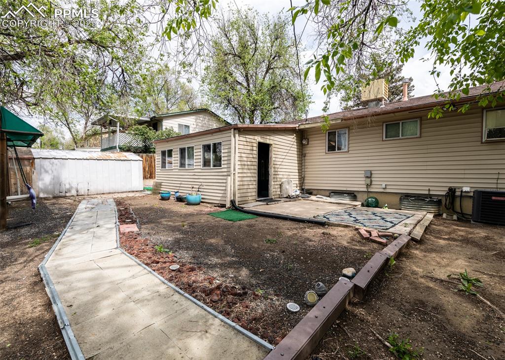 Image 39 of 42: Rear view of house with a patio area, fence, and cooling unit