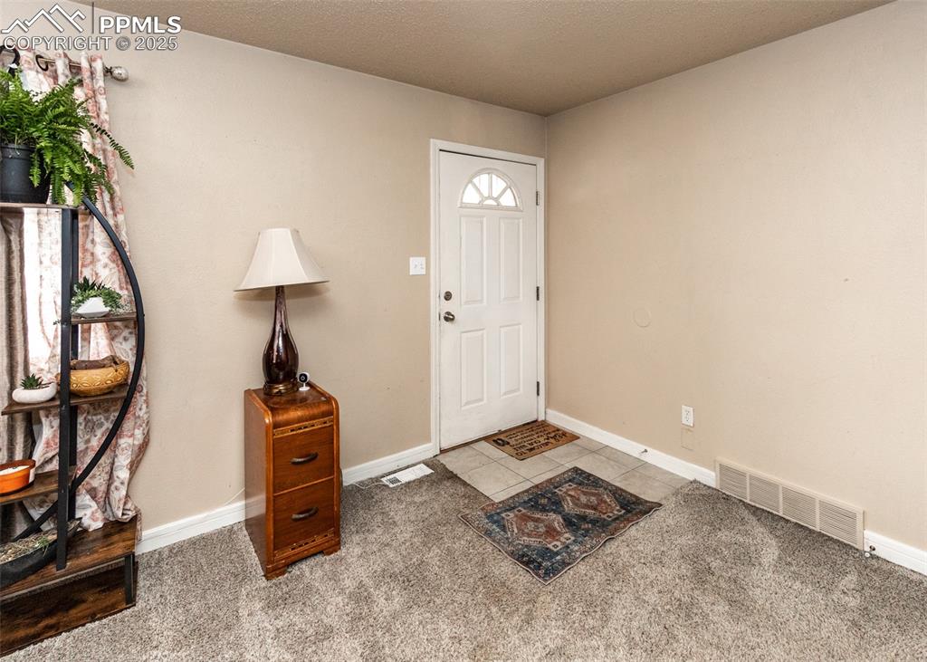 Image 4 of 42: Foyer featuring baseboards, light colored carpet, and light tile patterned